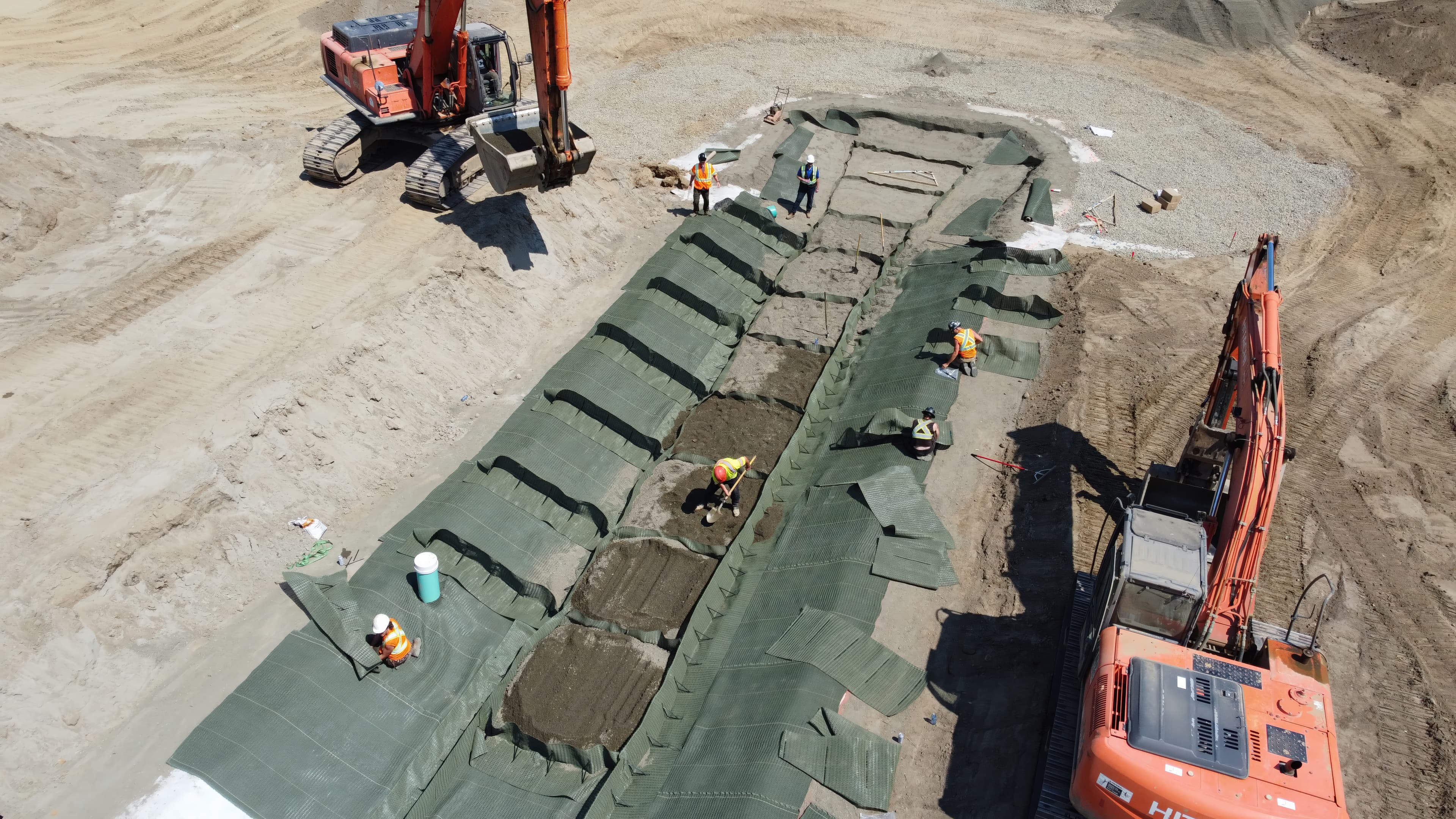 A crew manually installed PROPEX® Pyramattress® on the steep 26% grade, ensuring precise slope stabilization where machinery access was impossible.