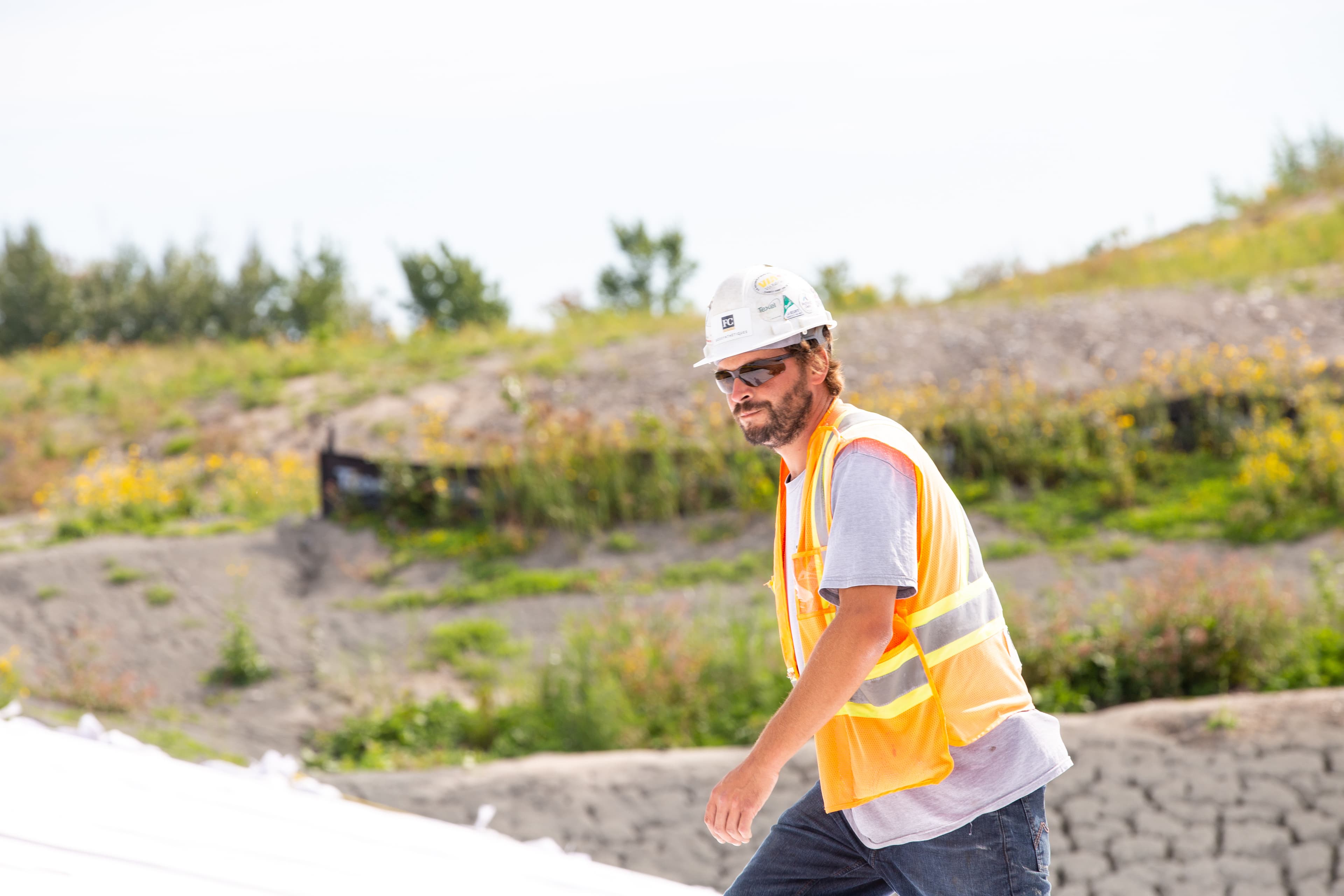 Staging of geosynthetics for the 23,300 m² cell footprint, coordinated to support the accelerated 10-day construction window achieved by FC Geosynthétiques.